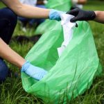 Group of volunteers cleaning a park, collecting garbage and saving the environment. Unrecognizable multi ethnic people.